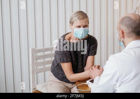 il medico calma il paziente agitato durante la visita. Foto Stock