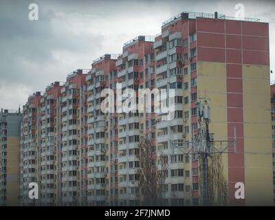 Casa a pannelli a più piani in cemento armato contro un cielo grigio. Tipico sviluppo urbano per le zone residenziali della Russia Foto Stock