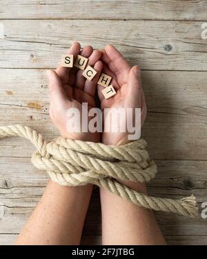 le mani maschili sono legate e tengono le lettere con la dipendenza di parola, la dipendenza di concetto, la foto scattata dall'alto Foto Stock