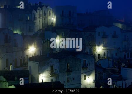 Monte Sant'Angelo città di Foggia, penisola del Gargano in Italia. Scena notturna con vecchi edifici con luci. Viaggi in Europa, serata magica. Foto Stock