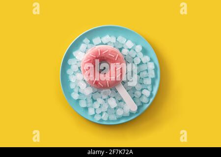 Popsicle di ciambelle di fragola e ghiaccio tritato su sfondo giallo. Foto Stock