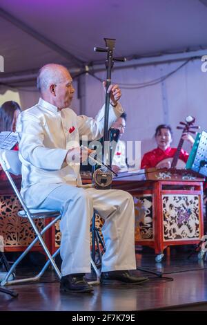 Un musicista che suona un huqin, un tradizionale strumento cinese strung. Si tratta di un tipo di fiddle con due grandi pioli di sintonizzazione Foto Stock