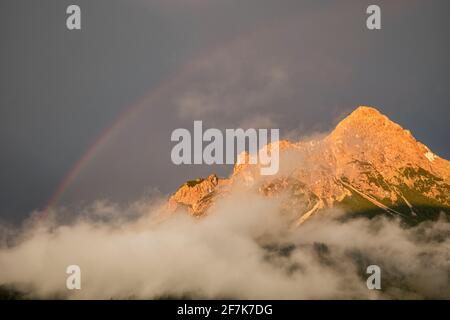 arcobaleno sulla cima della montagna dopo la pioggia al tramonto Foto Stock