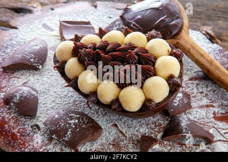 Uovo di pasqua brasiliano ripieno di cioccolato e crema, assaggiato con un cucchiaio. Tradizione pasquale in Brasile Foto Stock