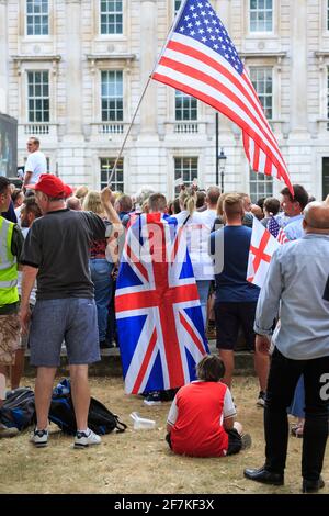 Manifestanti e attivisti in un raduno "Free Tommy Robinson" con Union Jack, bandiere inglesi e statunitensi, Whitehall, Londra Foto Stock