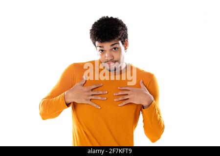 Un ragazzo afro perplesso che indossa un maglione arancione isolato su uno sfondo bianco Foto Stock