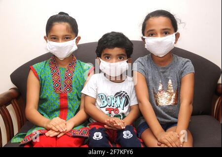 Bambini indiani che indossano maschera medica per la protezione personale contro l'inquinamento atmosferico o coronavirus COVID-19. Giovane hipster in maschera protettiva Foto Stock