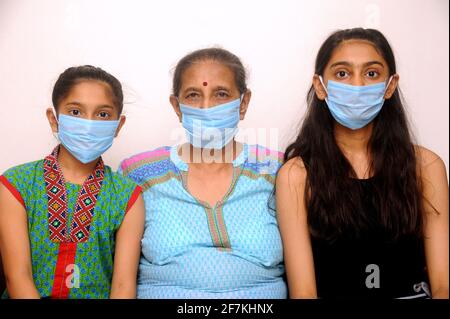 Famiglia indiana indossare maschera viso come protezione personale contro l'inquinamento atmosferico o coronavirus COVID-19. Giovane hipster in maschera protettiva sul viso Foto Stock