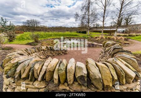 Area salotto circolare con pareti in arenaria e laghetto, giardino murato di Amisfield, East Lothian, Scozia, Regno Unito Foto Stock