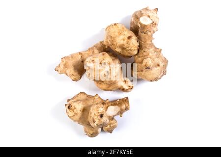 Tuberi di carciofi di Gerusalemme da vicino, isolati su un bianco. Foto Stock