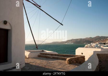 Una vista panoramica del villaggio di Chora da Windmill Hill sull'isola di Mykonos in Grecia. Sullo sfondo la costa e la montagna circostante Foto Stock