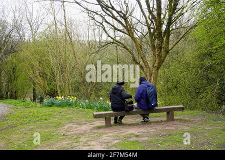 Una coppia riposa su un posto vicino al fiume Goyt a New Mills, Derbyshire Foto Stock