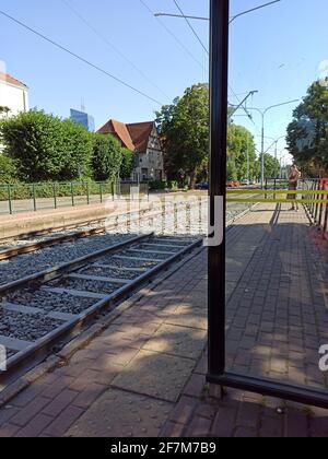 Gdansk, Polonia del Nord - 14 agosto 2020: Vista dall'interno di una stazione del tram o in piedi contro i binari e un passeggero in attesa di salire a bordo. Foto Stock