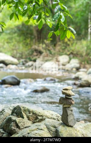 Rocce accatastate accanto al torrente nella foresta Foto Stock