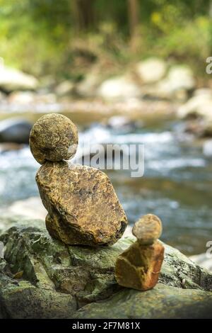 Rocce accatastate accanto al torrente nella foresta Foto Stock