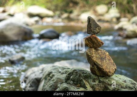 Rocce accatastate accanto al torrente nella foresta Foto Stock