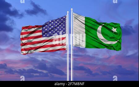 Pakistan e Stati Uniti due bandiere su flagpoli e blu cielo nuvoloso Foto Stock