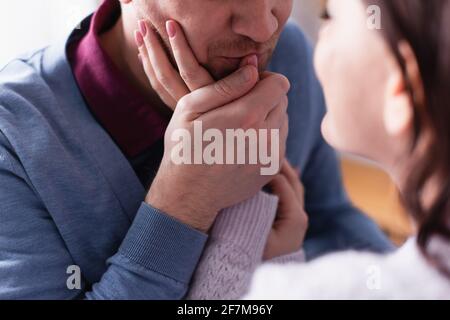 Uomo adulto baciando mano di moglie su primo piano sfocato Foto Stock