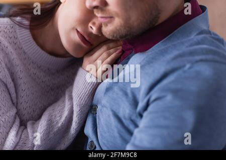 Vista ritagliata della donna che tocca la spalla del marito su offuscata primo piano Foto Stock