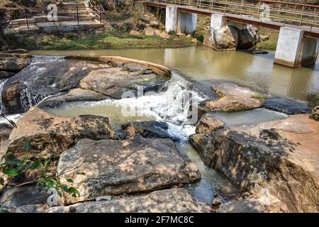 Piccolo serbatoio d'acqua in montagna di pietra con ponte per la comunicazione da un lato all'altro. Foto Stock