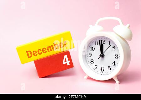 4 dicembre. Giorno 4 del mese, data del calendario. Sveglia bianca su sfondo rosa pastello. Mese invernale, concetto giorno dell'anno Foto Stock
