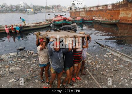 Keraniganj, Dhaka, Bangladesh. 8 Apr 2021. I lavoratori trasportano un pesante pezzo di lamiera in un cantiere navale sulla riva del fiume Buriganga, a Keraniganj, vicino a Dhaka, Bangladesh, 8 aprile; 2021. Con un numero crescente di ordini da parte di acquirenti locali e globali, l'industria cantieristica del Bangladesh sta prosperando rapidamente, contribuendo alla diversificazione del paniere di esportazione del paese e generando opportunità di lavoro. Credit: Suvra Kanti Das/ZUMA Wire/Alamy Live News Foto Stock