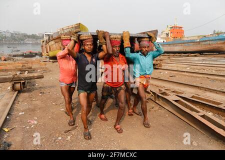 Keraniganj, Dhaka, Bangladesh. 8 Apr 2021. I lavoratori trasportano un pesante pezzo di lamiera in un cantiere navale sulla riva del fiume Buriganga, a Keraniganj, vicino a Dhaka, Bangladesh, 8 aprile; 2021. Con un numero crescente di ordini da parte di acquirenti locali e globali, l'industria cantieristica del Bangladesh sta prosperando rapidamente, contribuendo alla diversificazione del paniere di esportazione del paese e generando opportunità di lavoro. Credit: Suvra Kanti Das/ZUMA Wire/Alamy Live News Foto Stock