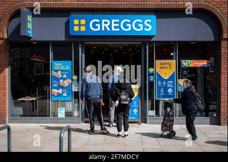 Watford, Regno Unito. 8 Apr 2021. Le persone si accodano per entrare in un ramo di greggs Bakers a Watford High Street, Hertfordshire, quando la zona diventa un po' più affollata, mentre le restrizioni di blocco del coronavirus vengono lentamente attenuate. I negozi non essenziali riapriranno il 12 aprile in conformità con la tabella di marcia del governo britannico, che incoraggerà un maggior numero di persone a visitare il centro della città. Credit: Stephen Chung/Alamy Live News Foto Stock