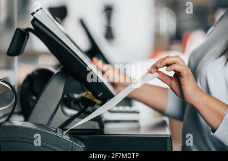 Venditore o acquirente che stampa una ricevuta o una fattura per un cliente, tempo di vendita, periodo di sconto, concetto POS Foto Stock