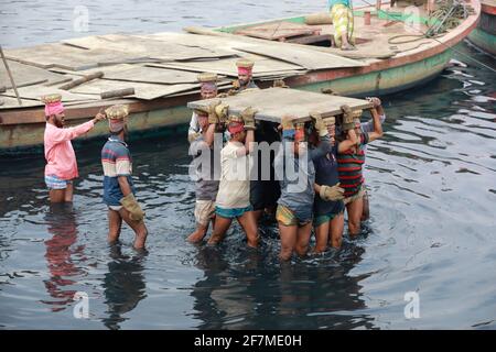 Keraniganj, Dhaka, Bangladesh. 8 Apr 2021. I lavoratori trasportano un pesante pezzo di lamiera in un cantiere navale sulla riva del fiume Buriganga, a Keraniganj, vicino a Dhaka, Bangladesh, 8 aprile; 2021. Con un numero crescente di ordini da parte di acquirenti locali e globali, l'industria cantieristica del Bangladesh sta prosperando rapidamente, contribuendo alla diversificazione del paniere di esportazione del paese e generando opportunità di lavoro. Credit: Suvra Kanti Das/ZUMA Wire/Alamy Live News Foto Stock