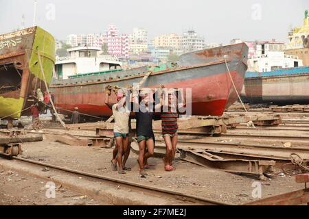 Keraniganj, Dhaka, Bangladesh. 8 Apr 2021. I lavoratori trasportano un pesante pezzo di lamiera in un cantiere navale sulla riva del fiume Buriganga, a Keraniganj, vicino a Dhaka, Bangladesh, 8 aprile; 2021. Con un numero crescente di ordini da parte di acquirenti locali e globali, l'industria cantieristica del Bangladesh sta prosperando rapidamente, contribuendo alla diversificazione del paniere di esportazione del paese e generando opportunità di lavoro. Credit: Suvra Kanti Das/ZUMA Wire/Alamy Live News Foto Stock