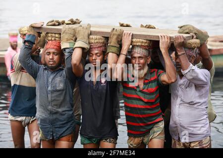 Keraniganj, Dhaka, Bangladesh. 8 Apr 2021. I lavoratori trasportano un pesante pezzo di lamiera in un cantiere navale sulla riva del fiume Buriganga, a Keraniganj, vicino a Dhaka, Bangladesh, 8 aprile; 2021. Con un numero crescente di ordini da parte di acquirenti locali e globali, l'industria cantieristica del Bangladesh sta prosperando rapidamente, contribuendo alla diversificazione del paniere di esportazione del paese e generando opportunità di lavoro. Credit: Suvra Kanti Das/ZUMA Wire/Alamy Live News Foto Stock