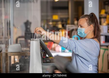 Venditore o shopgirl consegna il receptit o fattura dallo shopping nel centro del negozio, concetto di vendita del tessuto Foto Stock