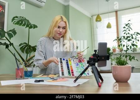 Teenage girl che registra video lezione di disegno usando smartphone su treppiede Foto Stock