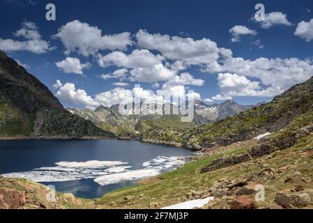 Lago di Certascan, nei Pirenei catalani in estate. Sullo sfondo, il massiccio della Pica d'Estats (Parco Naturale Alt Pirineu, Catalogna, Spagna, Pirenei) Foto Stock