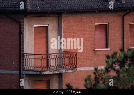 Appartamento abbandonato con facciate in mattoni e finestre chiuse, Italia Foto Stock