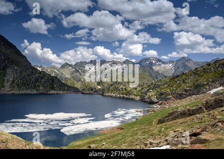 Lago di Certascan, nei Pirenei catalani in estate. Sullo sfondo, il massiccio della Pica d'Estats (Parco Naturale Alt Pirineu, Catalogna, Spagna, Pirenei) Foto Stock