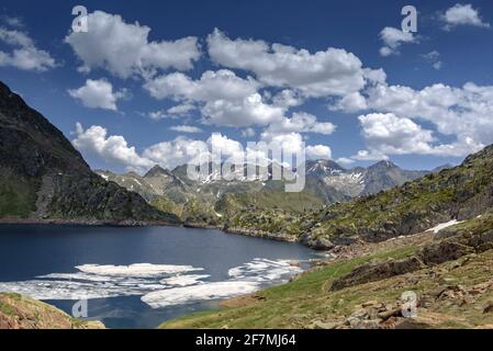 Lago di Certascan, nei Pirenei catalani in estate. Sullo sfondo, il massiccio della Pica d'Estats (Parco Naturale Alt Pirineu, Catalogna, Spagna, Pirenei) Foto Stock