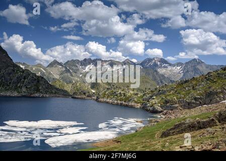 Lago di Certascan, nei Pirenei catalani in estate. Sullo sfondo, il massiccio della Pica d'Estats (Parco Naturale Alt Pirineu, Catalogna, Spagna, Pirenei) Foto Stock