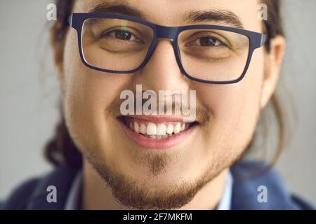 Uomo asiatico intelligente in occhiali con espressione sorridente ritratto viso primo piano Foto Stock
