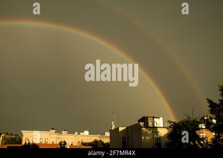 Un doppio arcobaleno su edifici di appartamenti a Brooklyn su un giornata cupa Foto Stock