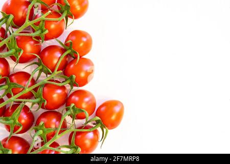 Ramo di pomodori ciliegini freschi isolato su sfondo bianco con copiare il testo sul lato destro Foto Stock