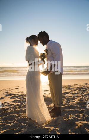 Coppia afroamericana innamorata sposarsi sulla spiaggia toccando fronte Foto Stock