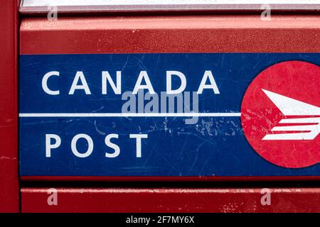 Londra, Ontario, Canada - Febbraio 15 2021: Rosso, blu e bianco Canada post-scatola di lettere in metallo, scatto fresco e primo piano del logo. Foto Stock