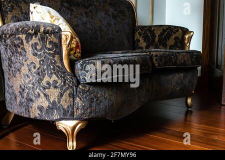 Foto angolata di un amorino francese in stile rinascimentale con motivo in pizzo nero e gambe dorate in Ontario, Canada, febbraio 2021. Foto Stock