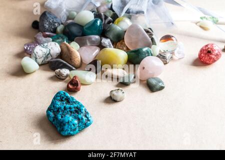 Una collezione di pietre preziose all'interno di una bustina di seta blu pallido versato su uno sfondo beige, Ontario, Canada, 2021. Foto Stock