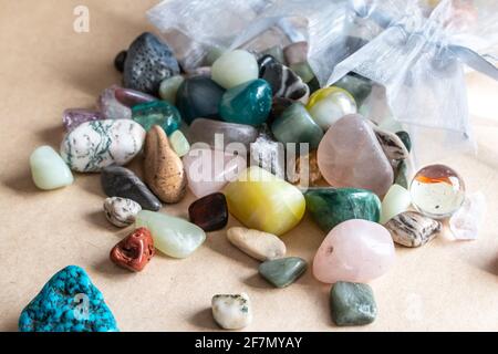 Una collezione di pietre preziose all'interno di una bustina di seta blu pallido versato su uno sfondo beige, Ontario, Canada, 2021. Foto Stock