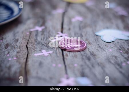 Closeup a pezzi di cioccolato a forma di monete rosa isolato su un rustico tavolo di legno. Presenta sfocatura davanti e dietro l'oggetto Foto Stock
