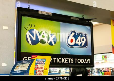 Londra, Ontario, Canada - Febbraio 26 2021: Una biglietteria lotto 649 nel Centro commerciale Sherwood Forest con una pila di carte Plinko davanti. Foto Stock