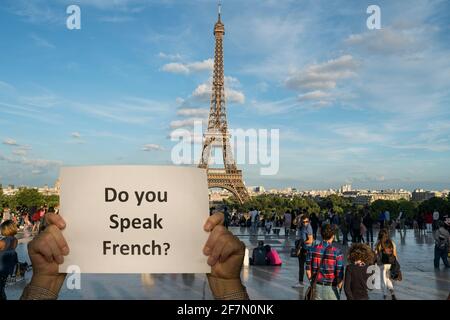 un uomo con un segno nelle mani e il Torre Eiffel sullo sfondo Foto Stock